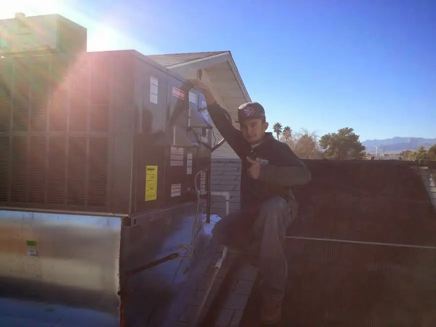 HVAC technician performing Boiler Repair on a rooftop unit in Fort Mill